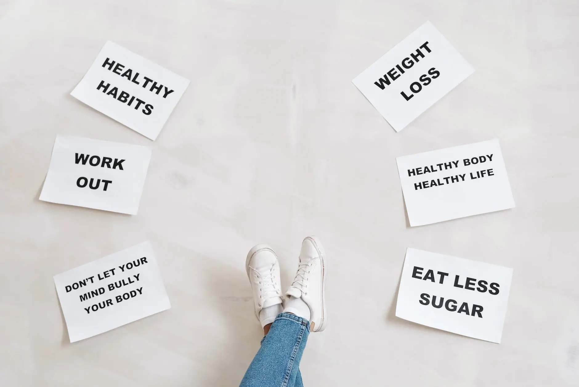 person legs with motivational words on papers on white background